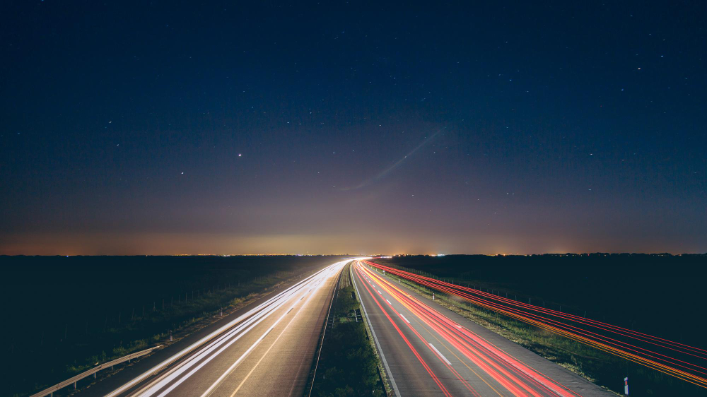 Vehicle lights streaking along a road at night
