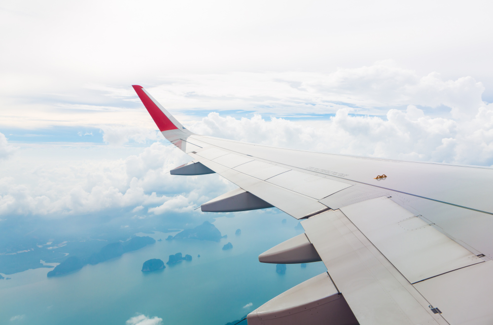Airplane wing over Indonesian islands - domestic flights in Indonesia