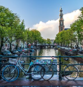 Rental bicycles locked along a canal bridge railing in central Amsterdam