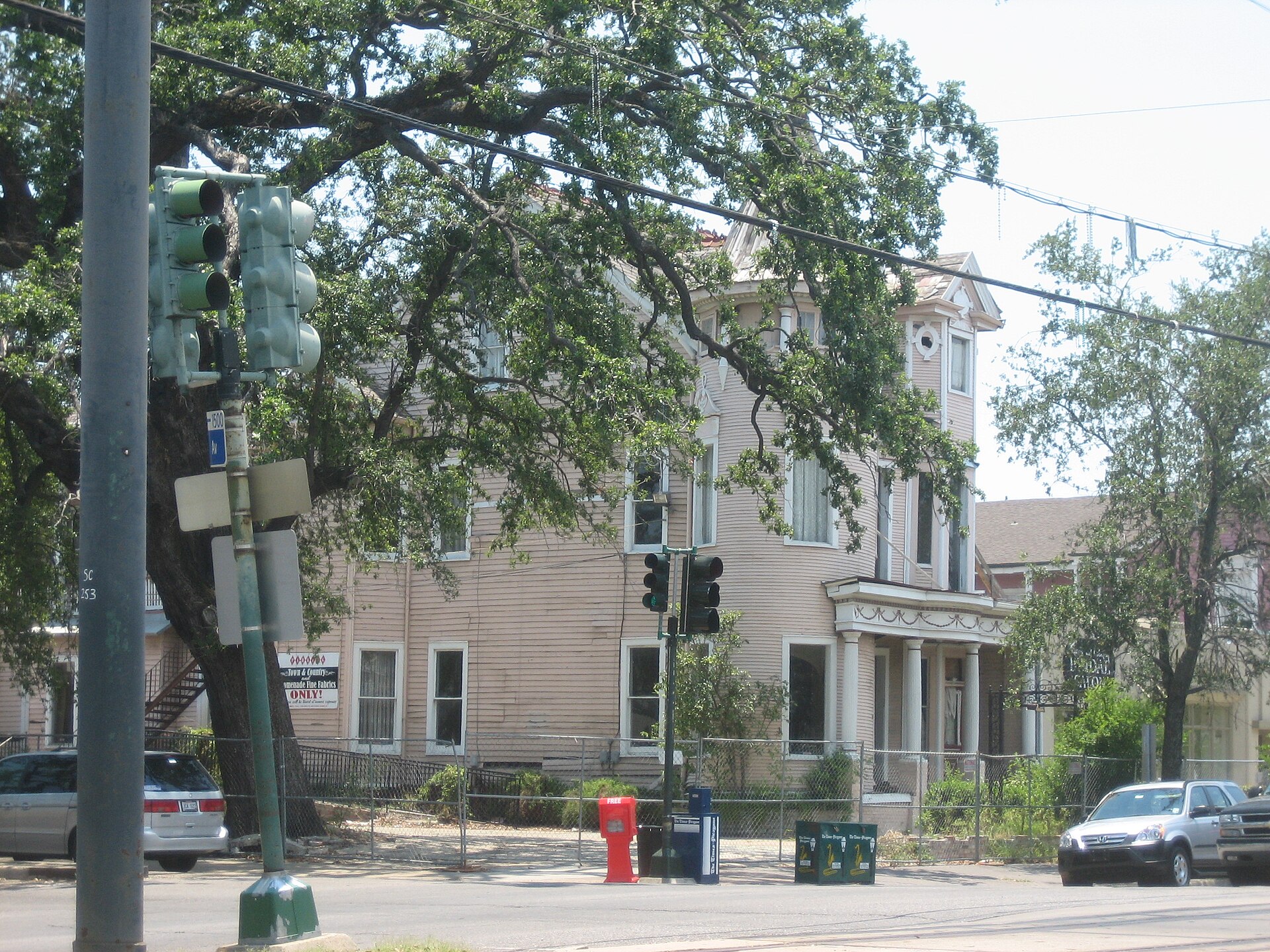 A columned antebellum mansion behind iron railings in the Garden District of New Orleans