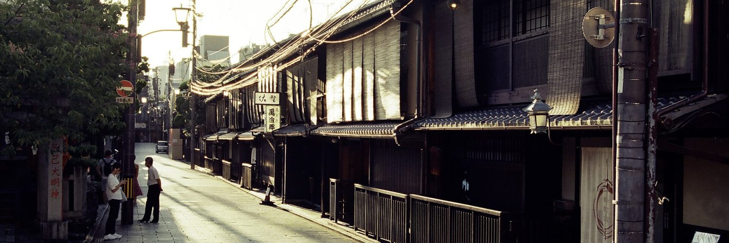 Traditional wooden machiya townhouses lining a narrow street in the Gion district of Kyoto