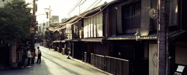 Traditional wooden machiya townhouses lining a narrow street in the Gion district of Kyoto