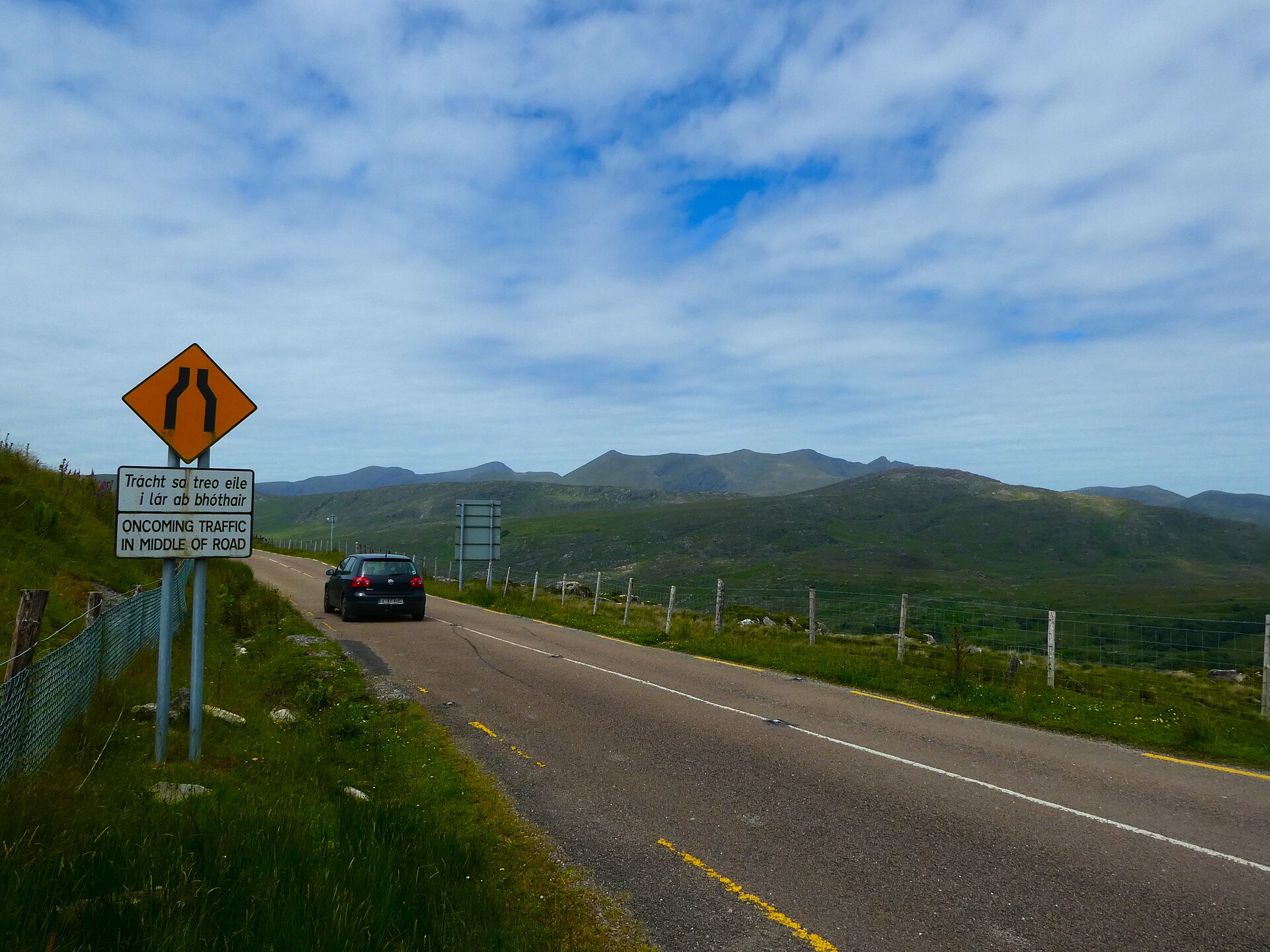 Irish road signage in Killarney showing bilingual place names and kilometre distances