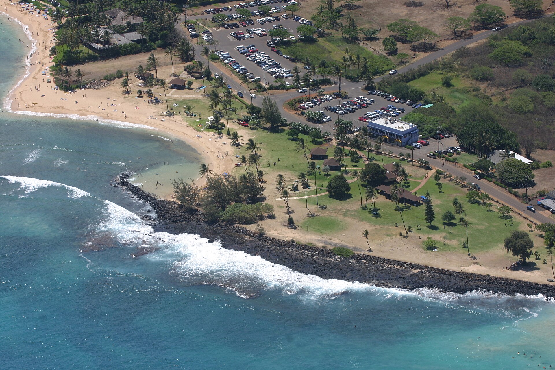 A beach on Kauai, Hawaii, with turquoise water and green cliffs behind