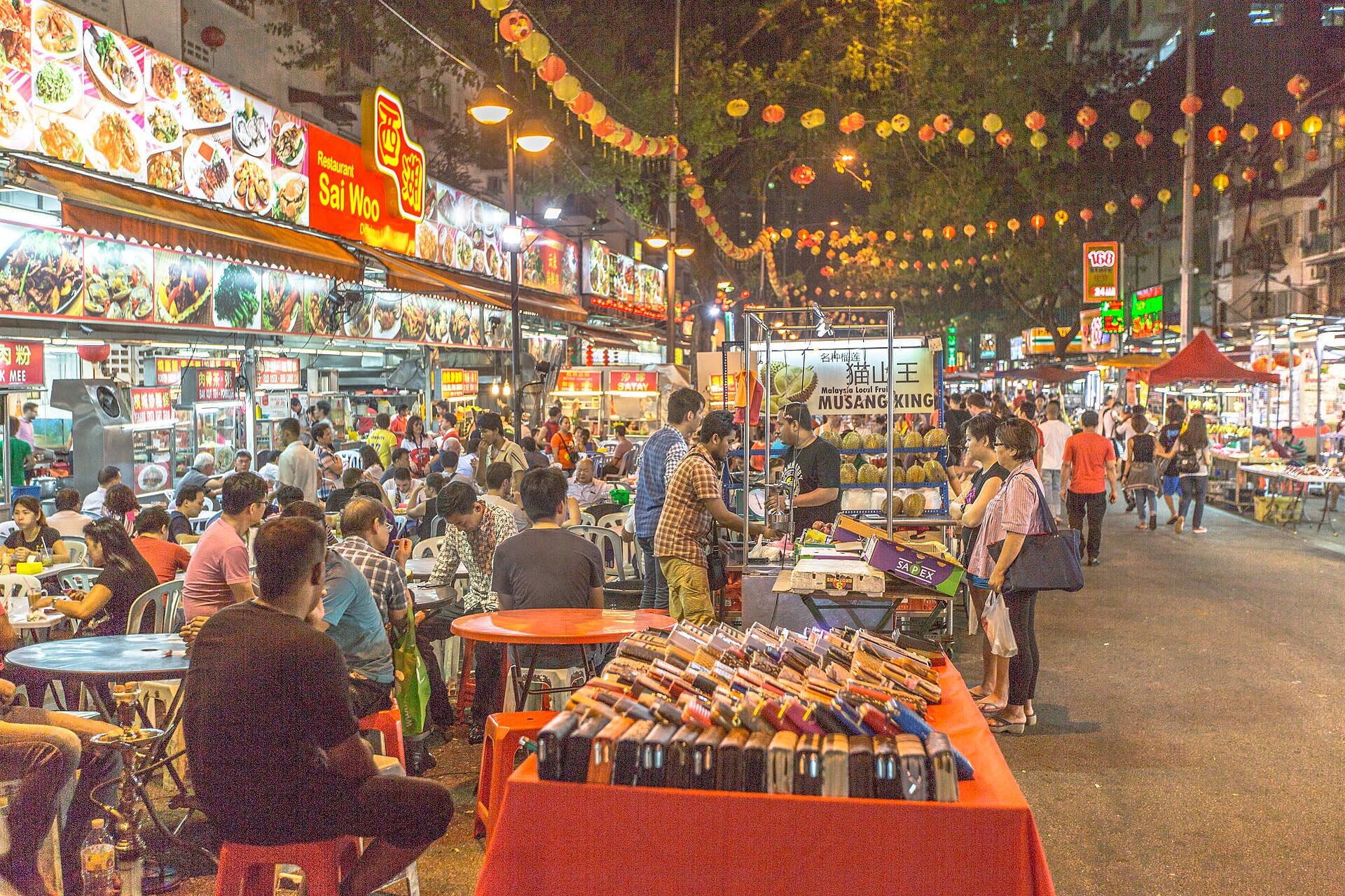 Plastic stools and hawker stalls filling Jalan Alor food street in Bukit Bintang at night