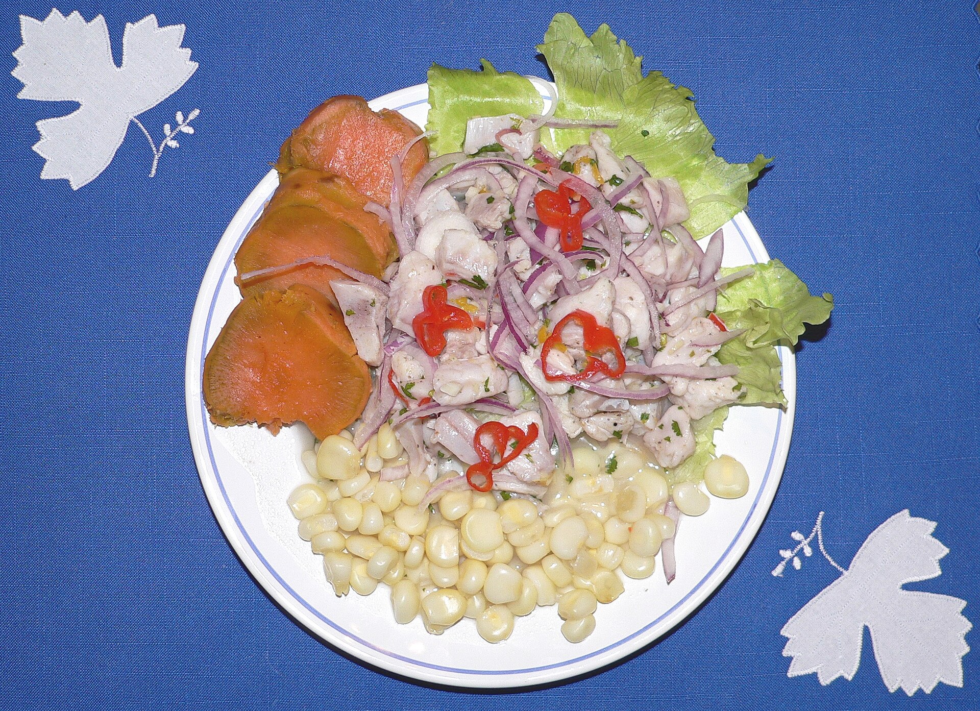A plate of Peruvian ceviche with sweet potato and corn