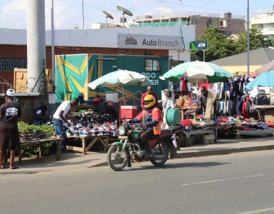 A boda boda motorcycle taxi rider waiting on a street in Nairobi