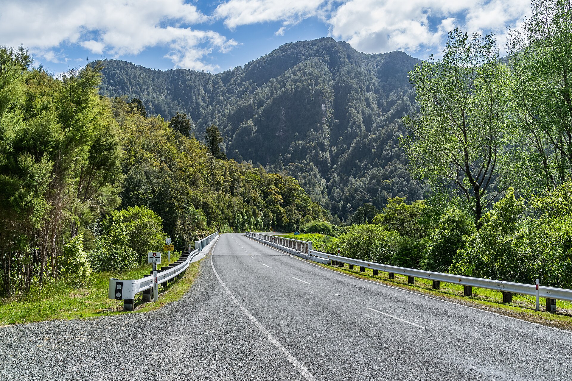 A two-lane New Zealand state highway curving through open countryside