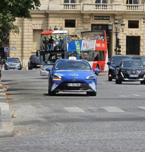 A licensed Paris taxi, a hydrogen Toyota Mirai, on a city street