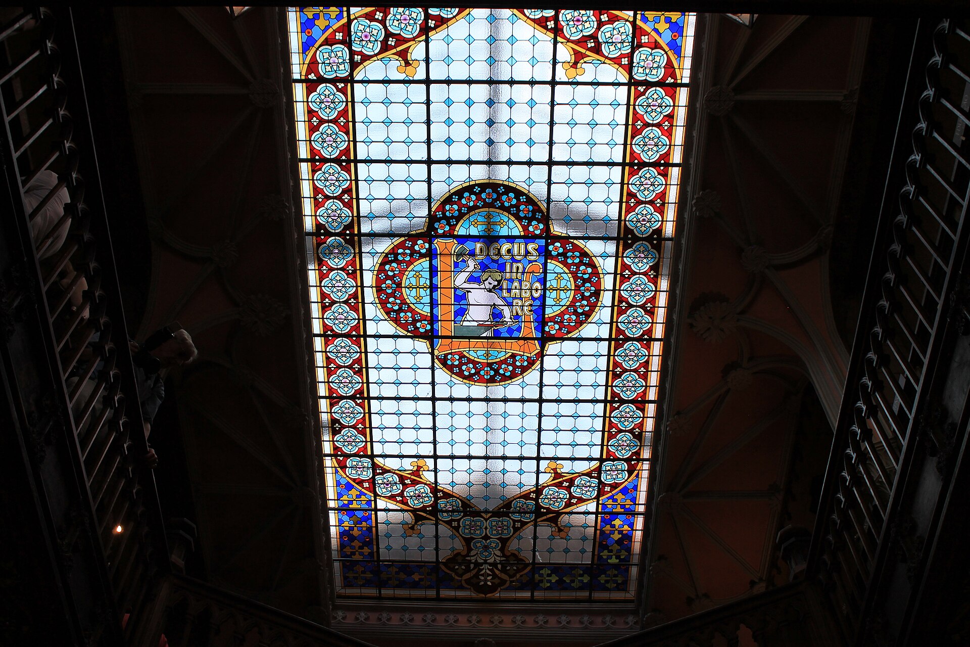 The red staircase and stained-glass ceiling inside Livraria Lello bookshop in Porto
