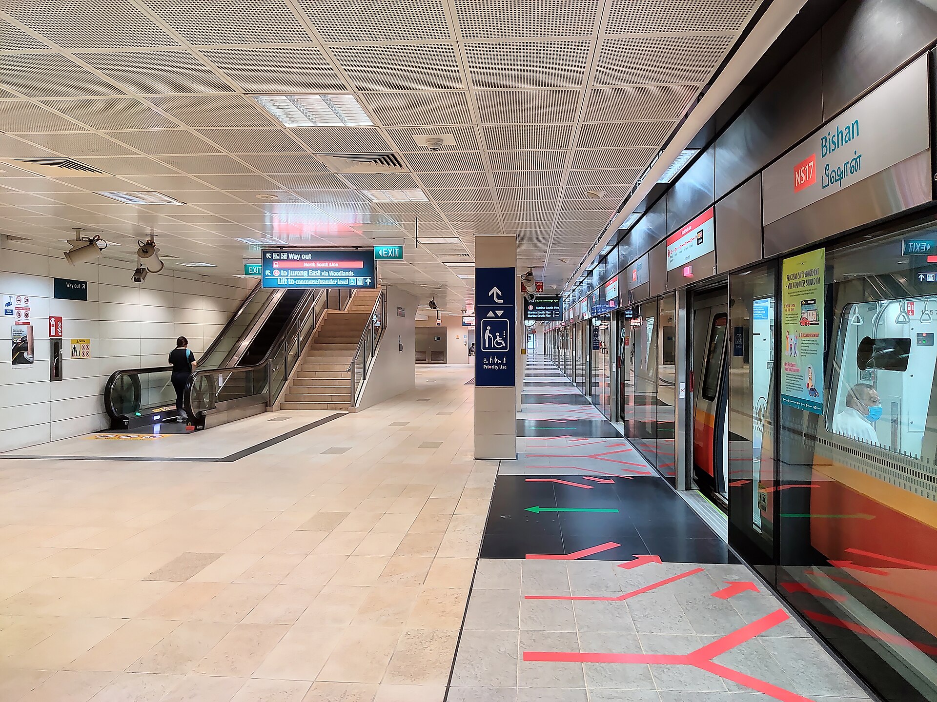 Passengers waiting on an MRT platform behind platform screen doors in Singapore
