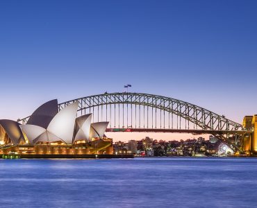 Sydney Opera House and Harbour Bridge at dusk seen across the harbour