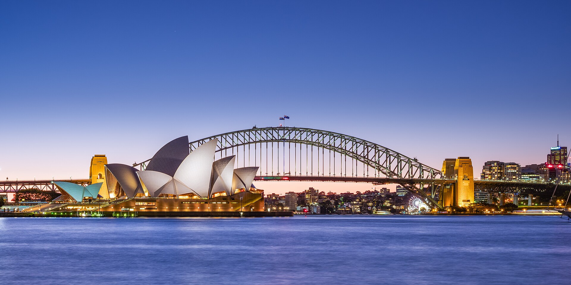 Sydney Opera House and Harbour Bridge at dusk seen across the harbour