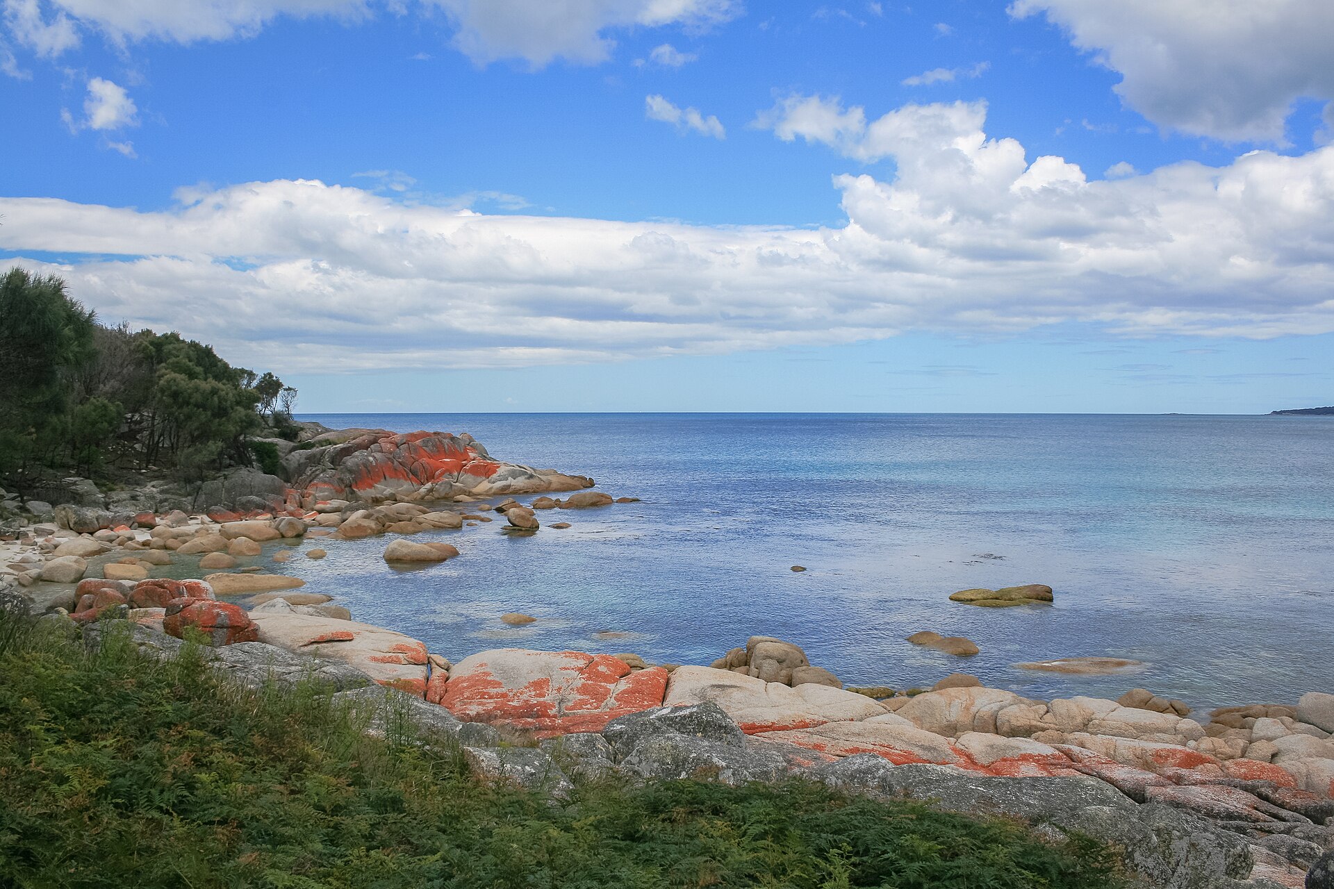 Orange lichen-covered granite boulders at the Bay of Fires
