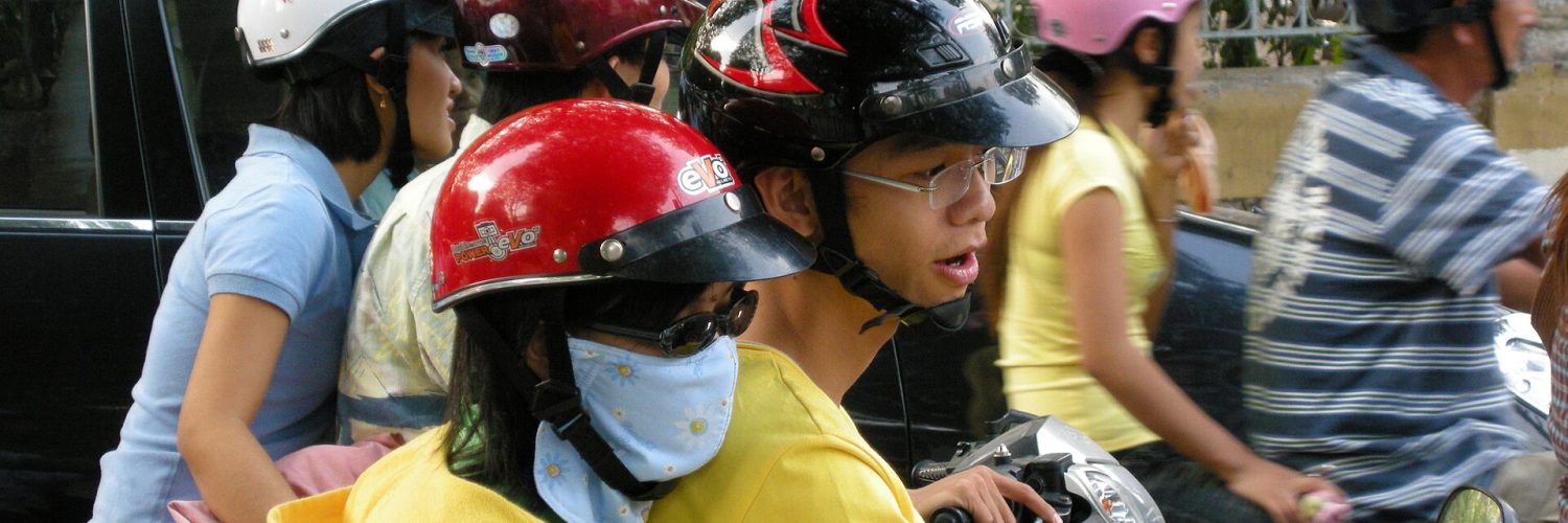 Dense scooter traffic on a street in Ho Chi Minh City