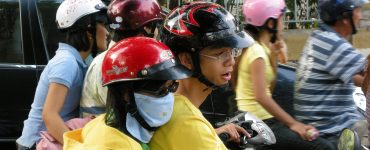 Dense scooter traffic on a street in Ho Chi Minh City