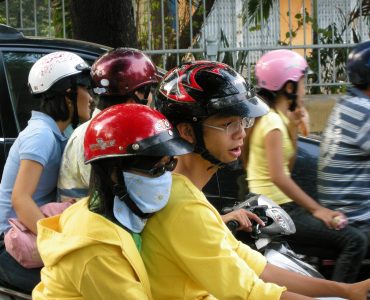 Dense scooter traffic on a street in Ho Chi Minh City