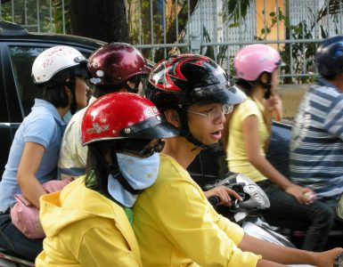 Dense scooter traffic on a street in Ho Chi Minh City