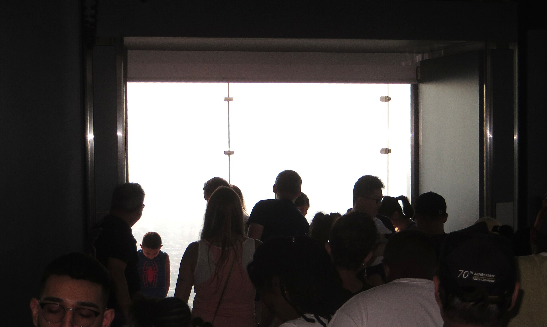 Visitors standing on The Ledge glass balcony at Skydeck Chicago in Willis Tower
