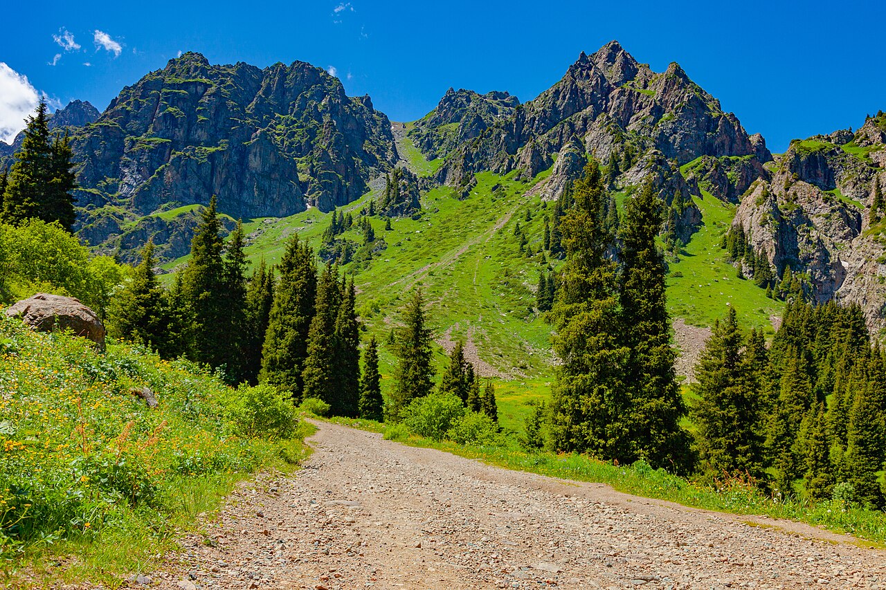Gravel mountain road winding up toward the Mynzhylky plateau above Almaty, Kazakhstan