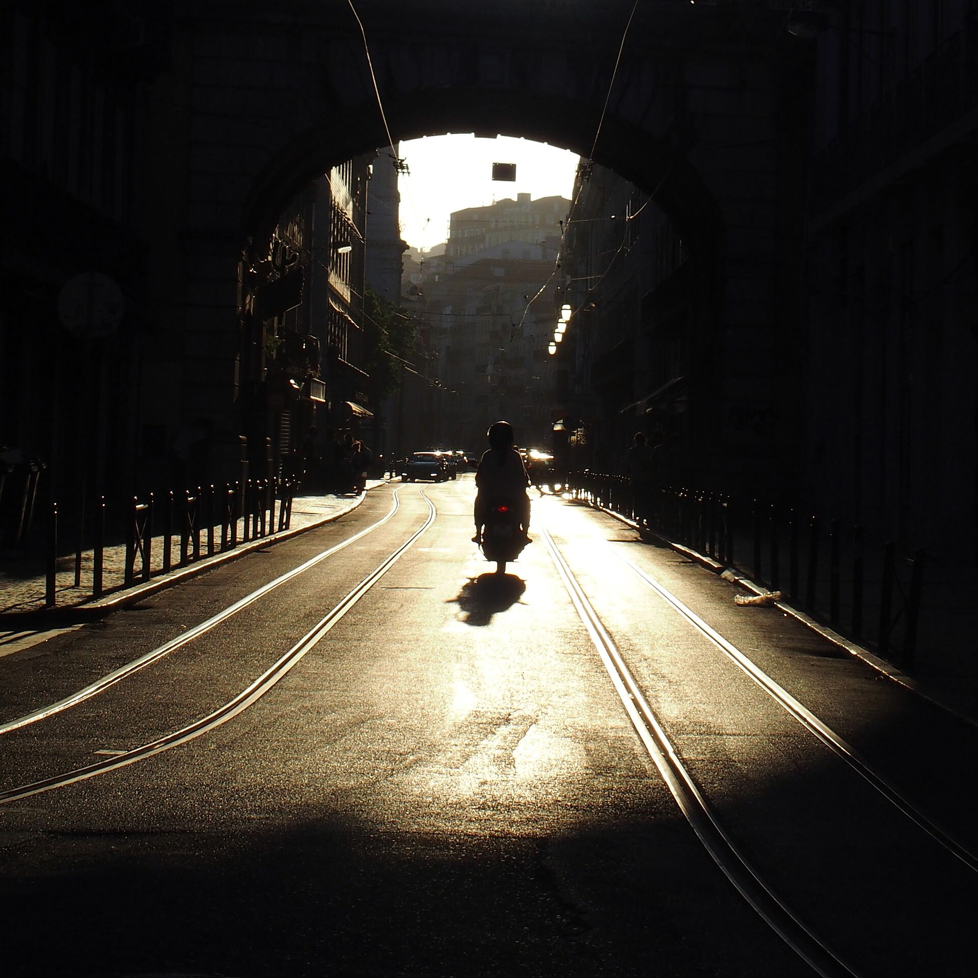 A scooter filtering between cars in dense city traffic