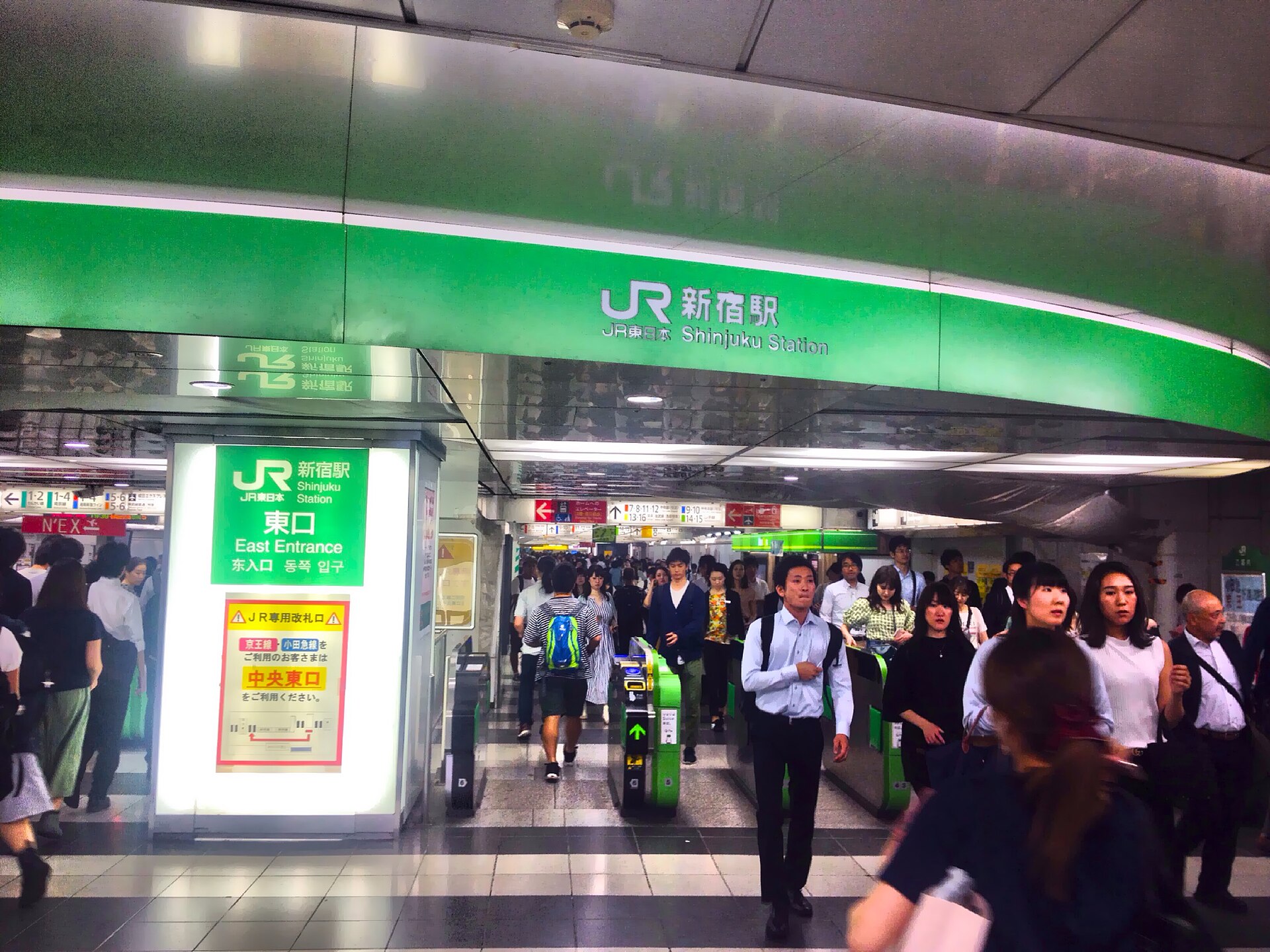 Crowds passing through the east exit ticket gates at JR Shinjuku Station in Tokyo
