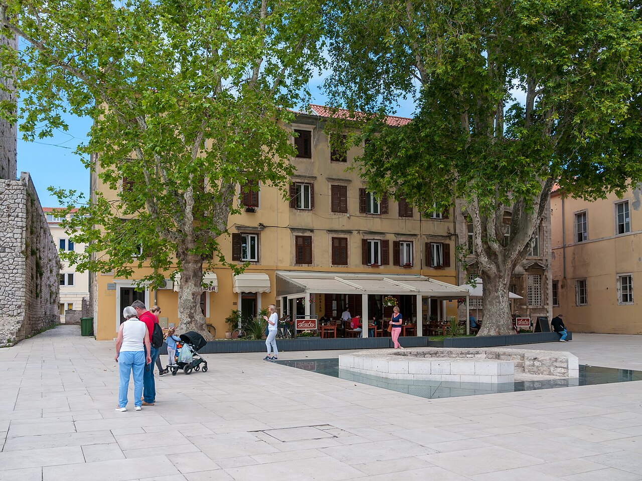 Narrow stone-paved street in Zadar old town, Croatia, lined with shuttered stone buildings